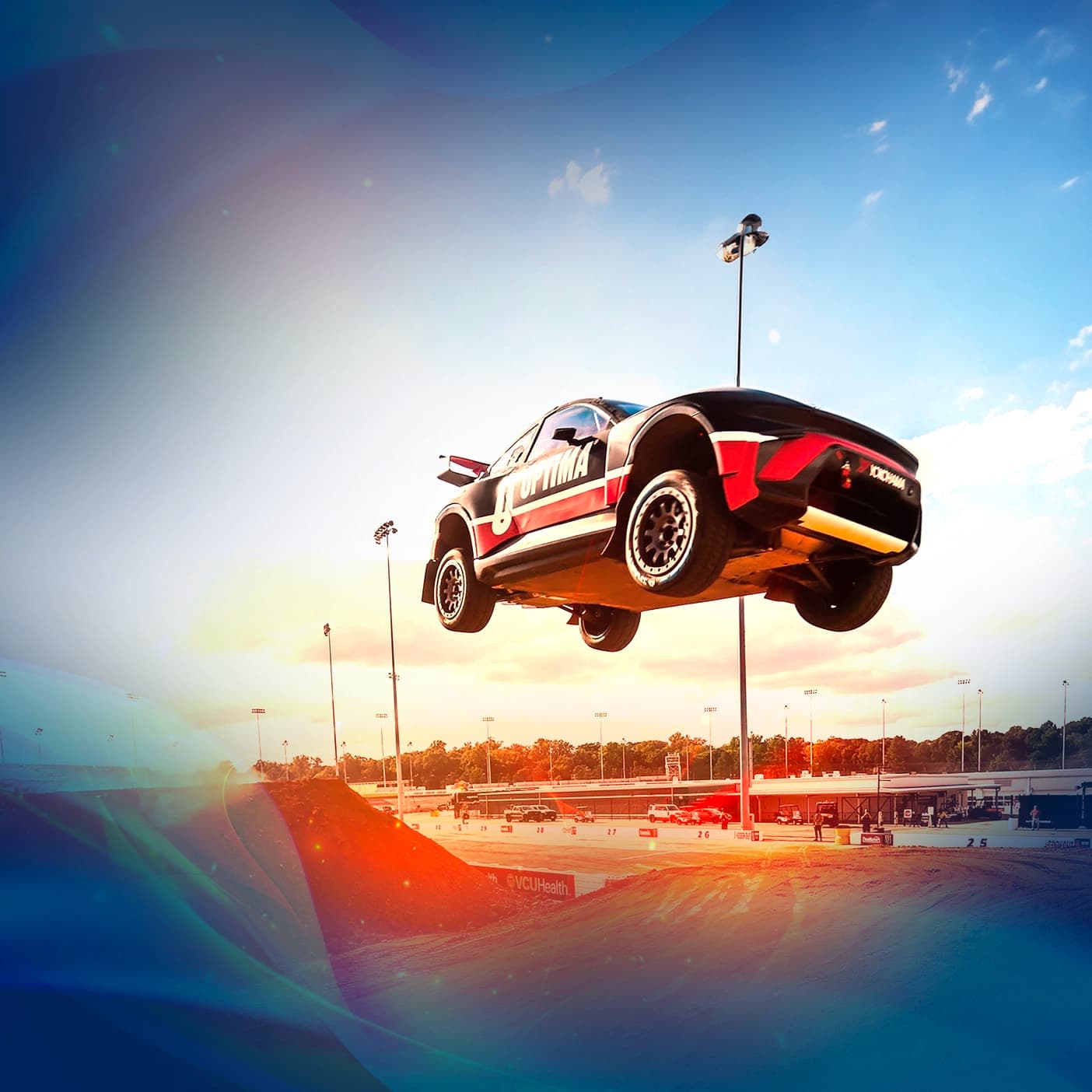 An Evo car flies off a ramp into the air at Nitrocross in Richmond, Virginia