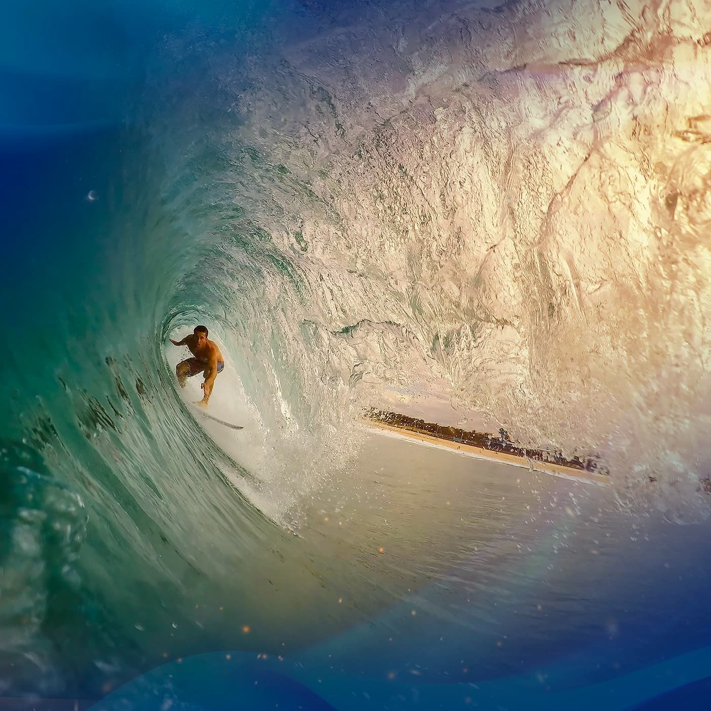 A surfer rides underneath a massive wave