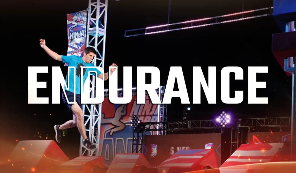 Athlete balancing mid-jump on an indoor obstacle course during a timed endurance challenge.