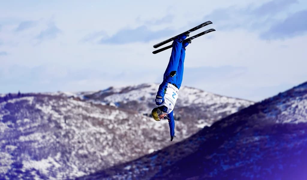 Freestyle skier inverted midair during an Olympic aerials event.
