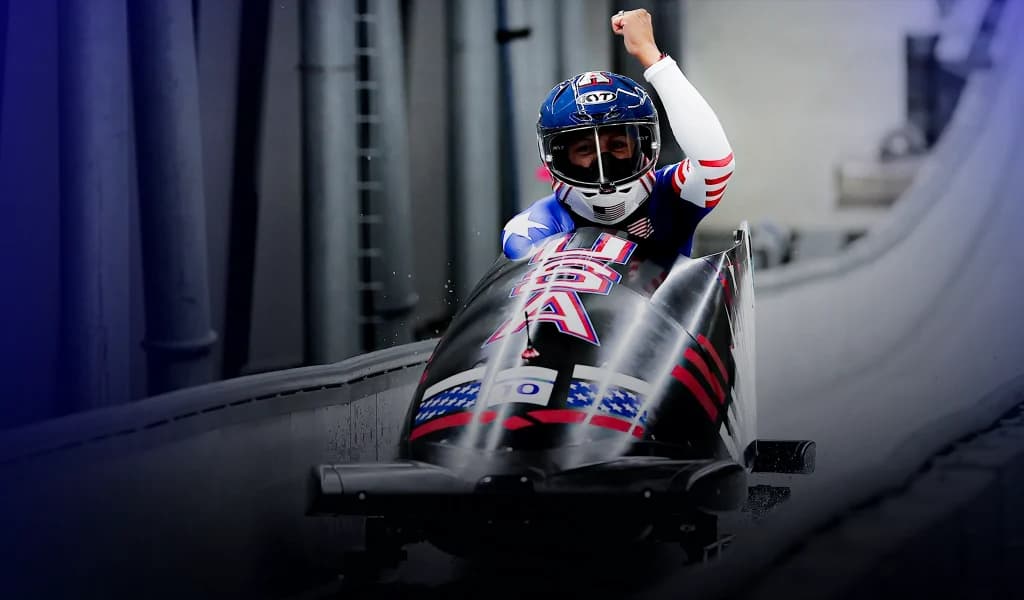 Elana Meyers Taylor raising her fist while racing in a USA bobsled.